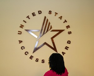 Regina Blye looking at Access Board Logo on a wall